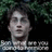 Pixelated image of a person with dark hair and glasses against a dark background with green foliage, accompanied by pixelated text in white.