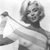 Pixelated grayscale image of a person with short hair holding a long object, wearing a light-colored top against a plain background.