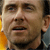 Pixelated close-up of a person's face showing eyes, nose, mouth, and partial ear with visible skin tones and background colors.