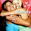 Two women embrace in a close hug, one in blue top, the other in green, against a red background with heart symbols and 'friends' text.
