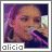 Alicia Keys singing into a microphone with a pink and black handle, wearing large hoop earrings and a dark top, with the name 'alicia' displayed below.