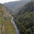Pixelated static image of a landscape with a waterfall flowing down a rocky slope surrounded by dense foliage under a hazy sky.