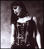 A grayscale image of a woman in gothic attire with red text overlays that change across frames, showing sequential phrases.