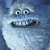 Pixelated blue-gray cartoon character with large eyes and a wide toothy grin, rendered in low-resolution style.