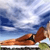 A pixelated image shows a brown and orange vehicle on a track with a blue sky background.