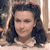 A static pixelated image shows a person with dark hair styled in waves, wearing a light-colored top against a blurred background.