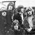 Black-and-white pixelated image showing a group of figures on the left and handwritten-style text 'PINK FLOYD' on the right.