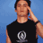 Four pixelated show a person in black sleeveless shirt with silver circular logo, hand near face against blue background