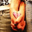 A pixelated static image shows a figure in orange and red tones with a pink heart symbol on the chest, set against a blurred background with indistinct text elements.