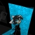 Pixelated blue triangular shape with a small dark figure holding a white object against a black background.