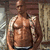 A static image of a muscular man in blue underwear standing against a textured background with overlaid text.