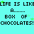A static digital image with cyan background, repeating text "LIFE IS LIKE A BOX OF CHOCOLATES!" in black pixelated font and green star accents.