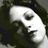 Pixelated grayscale image of a stylized human face with dark hair and light skin tones, rendered in low-resolution 256x256 pixels.