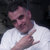 Pixelated image of a person in a white shirt making a hand gesture with fingers extended, set against a dark background.