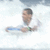 A person in a white shirt holds a blue object against a cloudy sky background with visible motion blur.