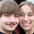 Two people with light brown hair pose closely together, smiling; green pixelated text overlays the right side of the image.