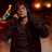 A pixelated image shows a person in dark clothing holding a microphone against a dark background with blurred lights, next to a bright cyan with pink text reading "I Luv Pete Wertz"