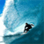 Pixelated static image of a surfer riding a wave in blue ocean water with white foam, viewed from above on a 50x50 icon frame.