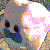 Pixelated image of a stylized animal head with large dark eyes, pink and orange accents on the right side, and scattered small red dots against a gray background.