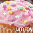 Pink-frosted cupcake with yellow, purple, and green sprinkles; white plus sign on top; 'yummy' text below in pixelated font.
