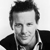 Black-and-white pixelated portrait of a man with short dark hair, wearing a collared shirt and jacket, displayed as a static AIM buddy icon on a white background.