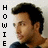 Pixelated image of a person with dark hair and light skin, wearing a dark shirt, with vertical text reading HOWIE on the left side.
