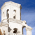 Pixelated image of a white building with columns against a blue sky background.