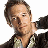 Pixelated image of a person with short brown hair wearing dark clothing and light-colored shirt, right arm extended forward.