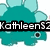 Pixelated teal dinosaur with light blue spikes and a single eye, overlaid with black text reading "KathleenS2" and a pink cartoon character with "Says" text.