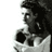 Pixelated grayscale image of a person's profile with dark hair and light clothing against white background, appearing as static single-frame icon.