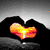 A static image shows two hands forming a heart shape with an orange glow inside, set against a gray gradient background.