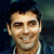 A pixelated image of a person with dark hair and light skin wearing a white shirt under a dark jacket, next to green text reading 'Original Icons .com' on a solid background.