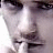 A pixelated close-up of a person's face with visible eyes, nose, and mouth against a light background.