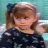 A static image shows a young girl with light brown hair in pigtails wearing a dark floral top, positioned left of repeated text and heart symbols.