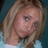 Pixelated close-up of a person with light brown hair, wearing a light blue top against a dark teal background.