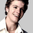 A person in a white collared shirt with dark hair, shown across four where the head turns slightly left to right while smiling