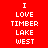 Red background with white pixelated text "I LOVE TIMBER LAKE WEST" arranged vertically, featuring a glowing effect on the left side of the text block.