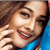 Pixelated close-up of a smiling person with brown hair wearing a blue top, visible teeth and red lips in a static 50x50 icon format.