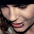 Pixelated close-up of a person's face with closed eyes, pink lips, and dark hair against a black background.