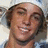 Pixelated image of a person with light brown hair wearing a white headband and blue clothing, set against black background with text.