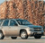 Static pixelated image of a light-colored vehicle with dark wheels and blue accents, positioned on a textured brown background.