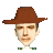 Pixelated portrait of a person wearing a brown wide-brimmed hat and a white shirt with green and blue striped collar, set against a solid gray background.
