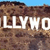 Pixelated image with large white text 'LLYXHO' overlaid on a brown textured background under a blue sky.