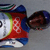 Pixelated static icon of a figure in winter sports attire with red, blue, green, and white colors against gray background.