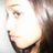 A pixelated close-up of a person's face with long dark hair, showing a slight shift in expression and a white text smiley face in the corner.