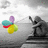 A static image shows a colorful cluster of overlapping rounded shapes on the left and a grayscale figure holding an object on the right against a light gray background.