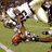 Pixelated image of a football player in white uniform holding red ball on green field with "touchdown" text.
