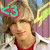 A person with light brown hair in a white jacket over red shirt appears in four with colored '<3' symbols in different positions