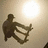 Pixelated image of a skateboarder performing a trick under a bright light source, with text elements below.