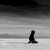 Black silhouette of a seated figure on a gradient background transitioning from dark gray at top to light gray at bottom.